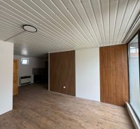 2-pokojový byt s podlahou s dřevěným dekorem a dřevěným obkladem na stěně.
