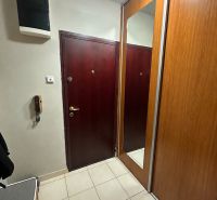Vstupní předsíň v 3-pokojovém bytě se zrcadlovou šatní skříní a světlou dlažbou.
