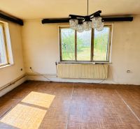 Pokoj v rodinném domě s podlahou s dřevěným dekorem a velkými okny.