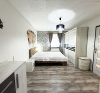 Ložnice v rodinném domě s podlahou s dřevěným dekorem a vkusným zařízením.