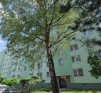 Považská Bystrica, Štúrova: Panelový dům obklopený stromy a zaparkovanými auty na ulici.