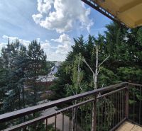Výhled z balkonu 4pokojového bytu v Myjavě zahrnuje stromy a panoráma města.