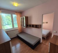 Pokoj s postelí, skříňkami a podlahou s dřevěným dekorem ve 4pokojovém bytě.