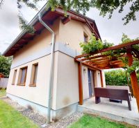 Chata v Moči na ulici Moča s terasou a dřevěnou pergolou, obklopená zahradou.