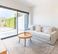 Rekreační apartmán s pohodlnou pohovkou, stolkem a velkým oknem.