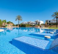 Bazén u rekreačního apartmánu v Cala Murada na Mallorce s palmami a lehátky.