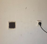 Stěna s elektrickou zásuvkou v garážích na Jesenského ulici ve Zvolenu.