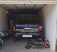 Garáž s autem a elektrickou koloběžkou, uloženými předměty a kresbou na dveřích.