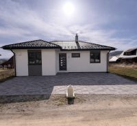 Rodinný dům v Ižipovcích s parkovacími místy a kachlovou střechou pod slunečnou oblohou.
