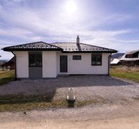 Rodinný dům v Ižipovcích s jednoduchou fasádou a šikmou střechou na slunném pozemku.