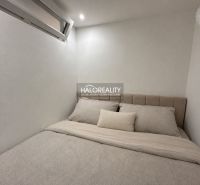 Hostinský pokoj v jednopokojovém bytě s minimalistickým designem a pohodlným lůžkem.