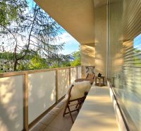 Balkon 2pokojového bytu s výhledem na zeleň a pohodlným sezením.