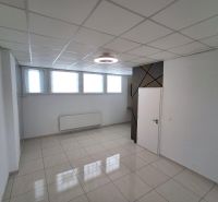 Kanceláře se světlou dlažbou, bílými stěnami a okny, jednoduchý stropní design.