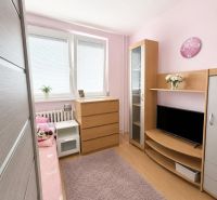Dětský pokoj s podlahou s dřevěným dekorem, růžovými stěnami a dřevěným nábytkem ve 3-pokojovém bytě.