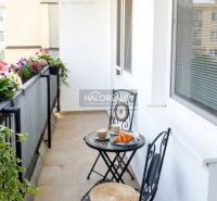 Balkon s květinami a posezením ve 3-pokojovém bytě v Trnavě.