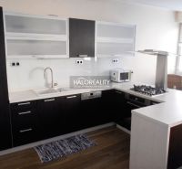 Kuchyně v 3-pokojovém bytě s podlahou s dřevěným dekorem a moderní linkou.