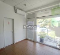 Obchodní prostory s dlažbou, klimatizací a moderními prosklenými dveřmi.