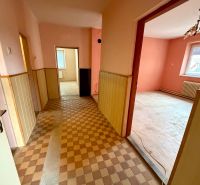Světlý interiér Rodinného domu s dlaždičkovou podlahou, růžovými stěnami a dřevěnými obklady.