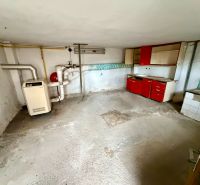 Sklep rodinného domu s kotlem a starou kuchyňskou linkou v Rovensku.