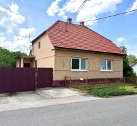 Rodinný dům v Rovensku se šikmou červenou střechou a železnou bránou.