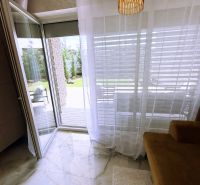 Otevřený balkon v 2-pokojovém bytě s dlažbou imitující mramor a stylovým osvětlením.