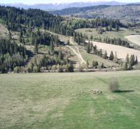Zemědělské a lesní pozemky v Černém Balogu s kopci, lesy a cestou v krajině.