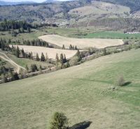 Kopcovitá krajina v Černém Balogu se zemědělskými a lesními pozemky plná stromů a luk.