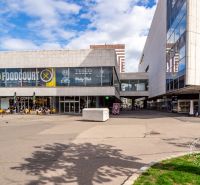 Nákupní centrum v Bratislavě s restaurační zónou a venkovním posezením před kavárnou.