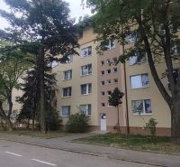 Bytový dům na Exnárově ulici v Bratislavě - Ružinově obklopený stromy.