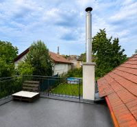 Střešní terasa rodinného domu v Šalgovcích s komínem a výhledem na zahradu.