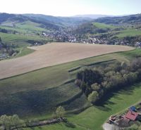 Krajina v Čiernom Balogu se zemědělskými a lesními pozemky na svazích kopců.