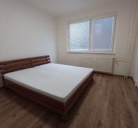 Ložnice s postelí a podlahou s dřevěným dekorem v 3-pokojovém bytě.