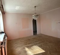 Pokoj se světlým osvětlením a podlahou s dřevěným dekorem ve 3-pokojovém bytě.
