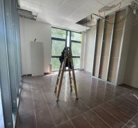 Kanceláře s žebříkem a rozestavěným podhledem, podlaha s dřevěným dekorem.