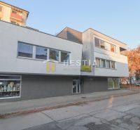 Obchodní prostory v Senici, moderní budova se skleněnými výlohami na pěší zóně.
