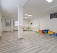 Prostorné obchodní prostory s podlahou s dřevěným dekorem a barevnými sedacími prvky.
