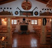 Interiér restaurace v hotelech a penzionech s dřevěnými prvky a krbem.
