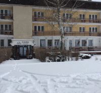 Hotel a penzion v Liptovském Jánu se zasněženou střechou a exteriérem.