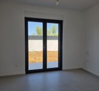 Pokoj ve 4-pokojovém bytě s velkým oknem a dlažbou na podlaze.