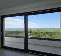 Velké okno ve 4pokojovém bytě nabízí panoramatický výhled na přírodu a moře.