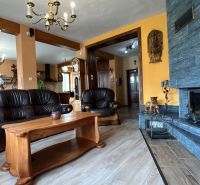 Kožená sedací souprava a krb, podlaha s dřevěným dekorem, elegantní interiér vily.