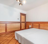 Ložnice ve 3pokojovém bytě s dřevěným obložením a podlahou s dřevěným dekorem.