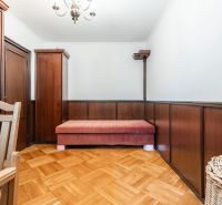 Pokoj v 3-pokojovém bytě s dřevěným obkladem a podlahou s dřevěným dekorem.