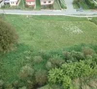 Travnaté pozemky pro bydlení ve Slovenské Volové obklopené zelení a domy.