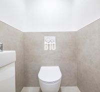 Koupelna v 3-pokojovém bytě s WC a umyvadlem, jednoduché obklady na stěnách.