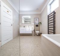 Prostorná koupelna v rodinném domě s elegantní vanou a moderním umyvadlem.