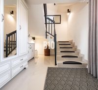Schodiště a bílý nábytek dodávají Rodinnému domu pocit vzdušnosti a stylu.