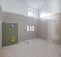 Nedokončená místnost s oknem a přípravou na instalaci v rodinném domě.