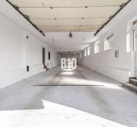 Prostorná garáž v rodinném domě ve městě Nitra s několika okny a bílými stěnami.
