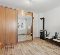 Pokoj v rodinném domě s krbem, skříní a podlahou s dřevěným dekorem.